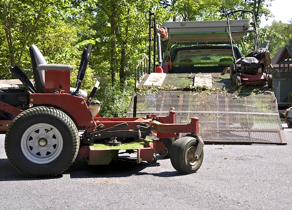 lawn mower being loaded onto a truck